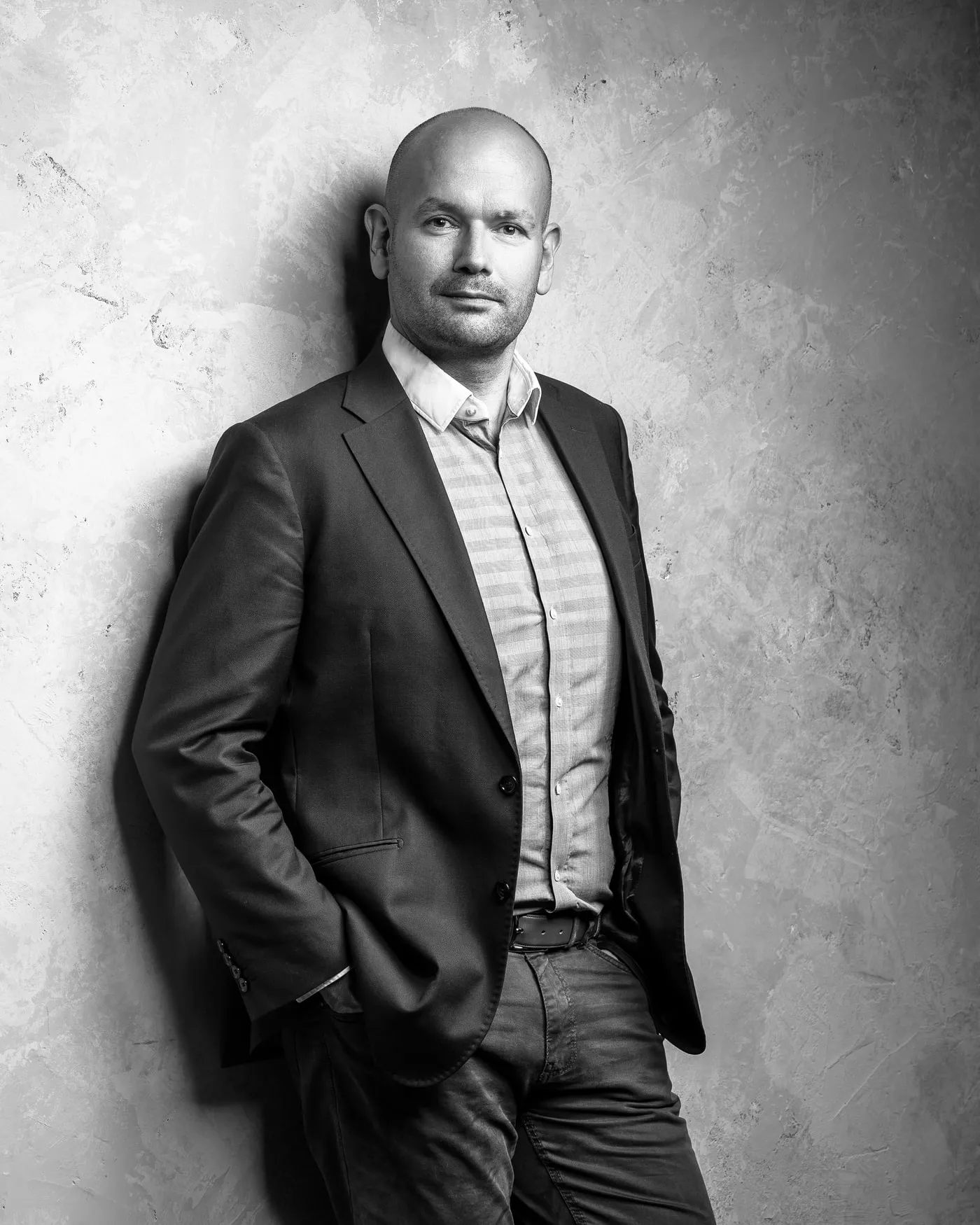 Jan Romportl, black and white portrait against a concrete wall